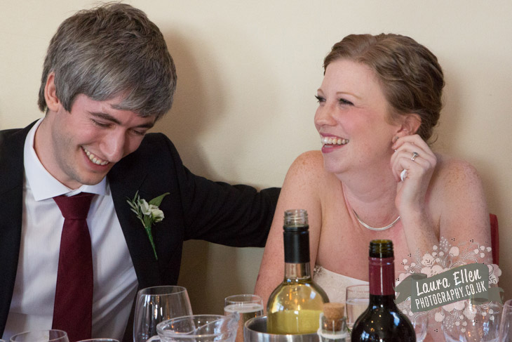 Bride and Groom laughing at wedding speeches